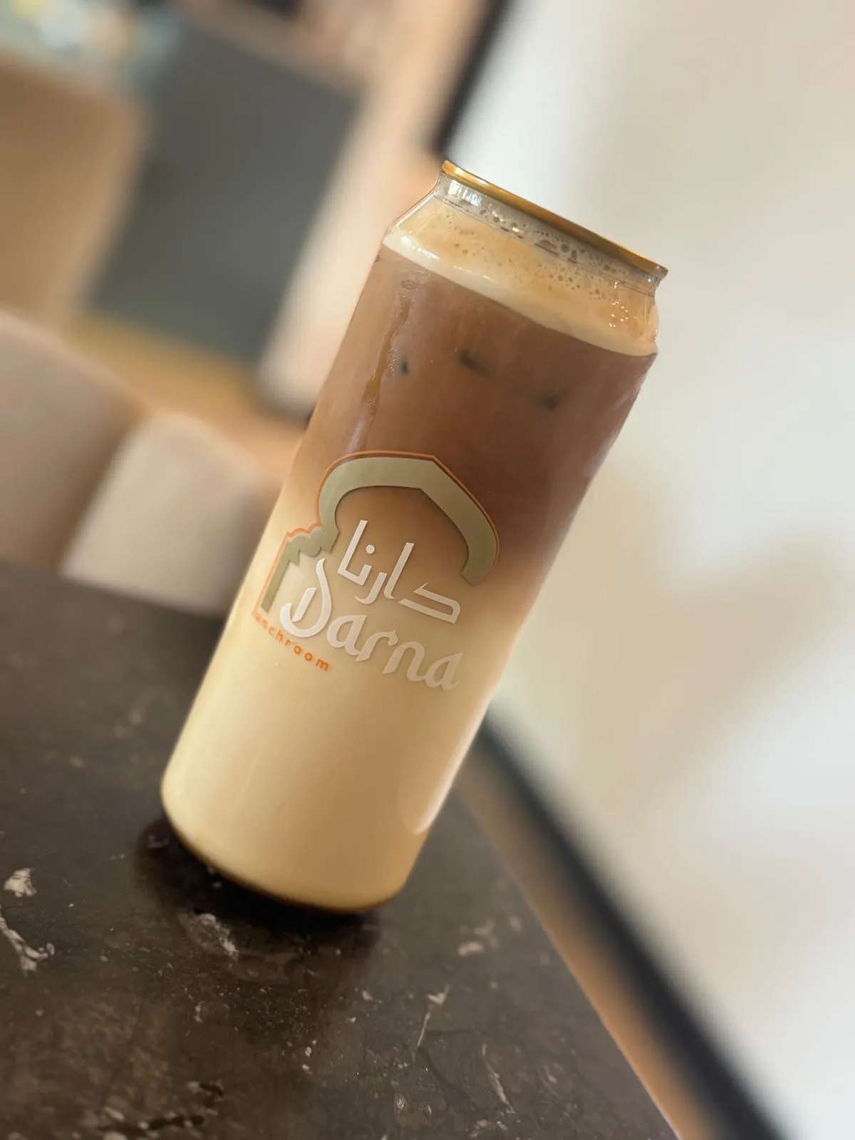 IJskoffie met melk in een Darna-blikje op een zwart marmeren tafel