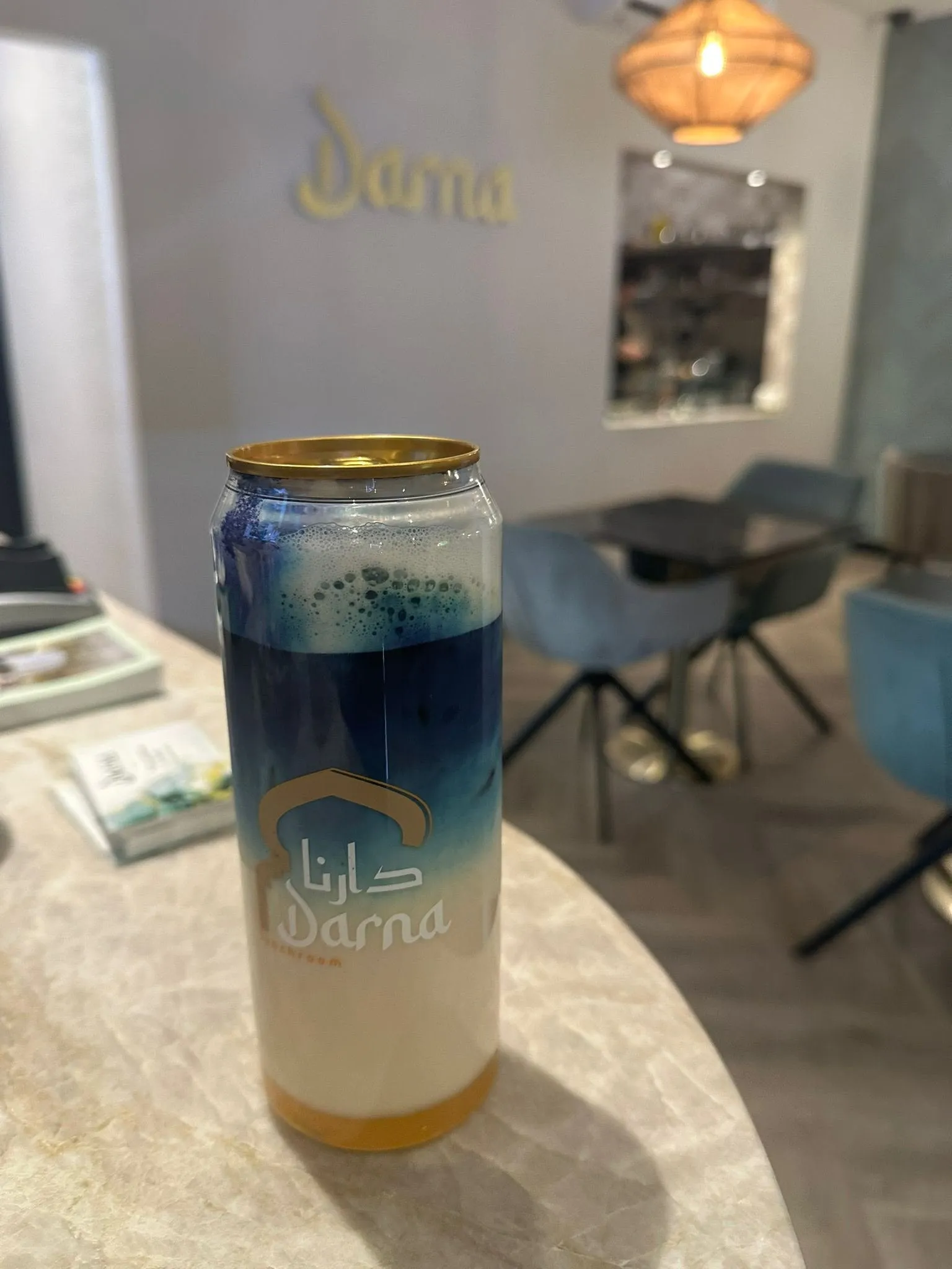 Een blikje Darna matcha special op de bar: diepblauwe matcha van vlindererwtbloem boven een laag melk en siroop onderin